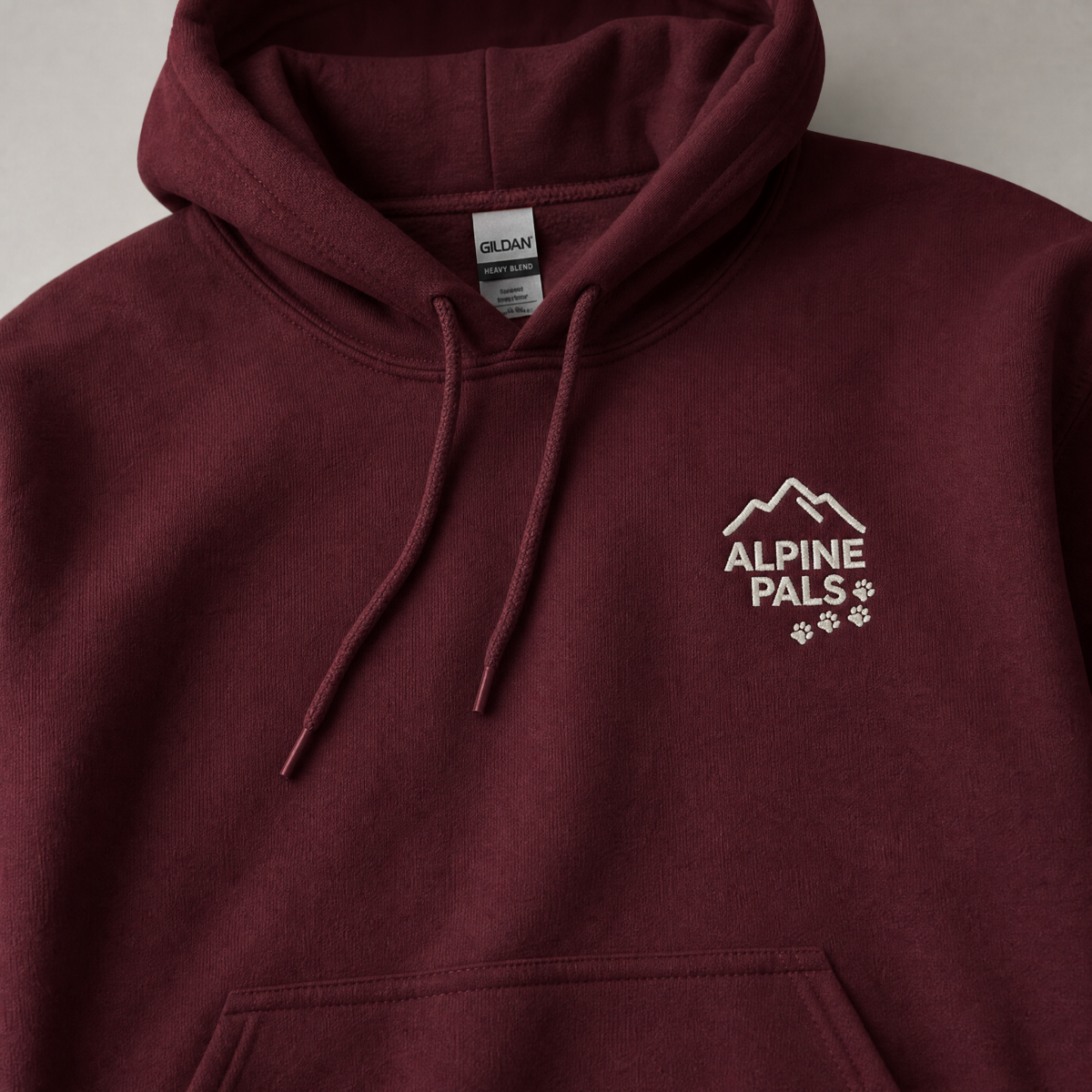 Maroon hoodie with 'Alpine Pals' logo on a neutral background