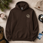 Dark chocolate brown hoodie with 'Alpine Pals' logo on a wooden surface with winter accessories.