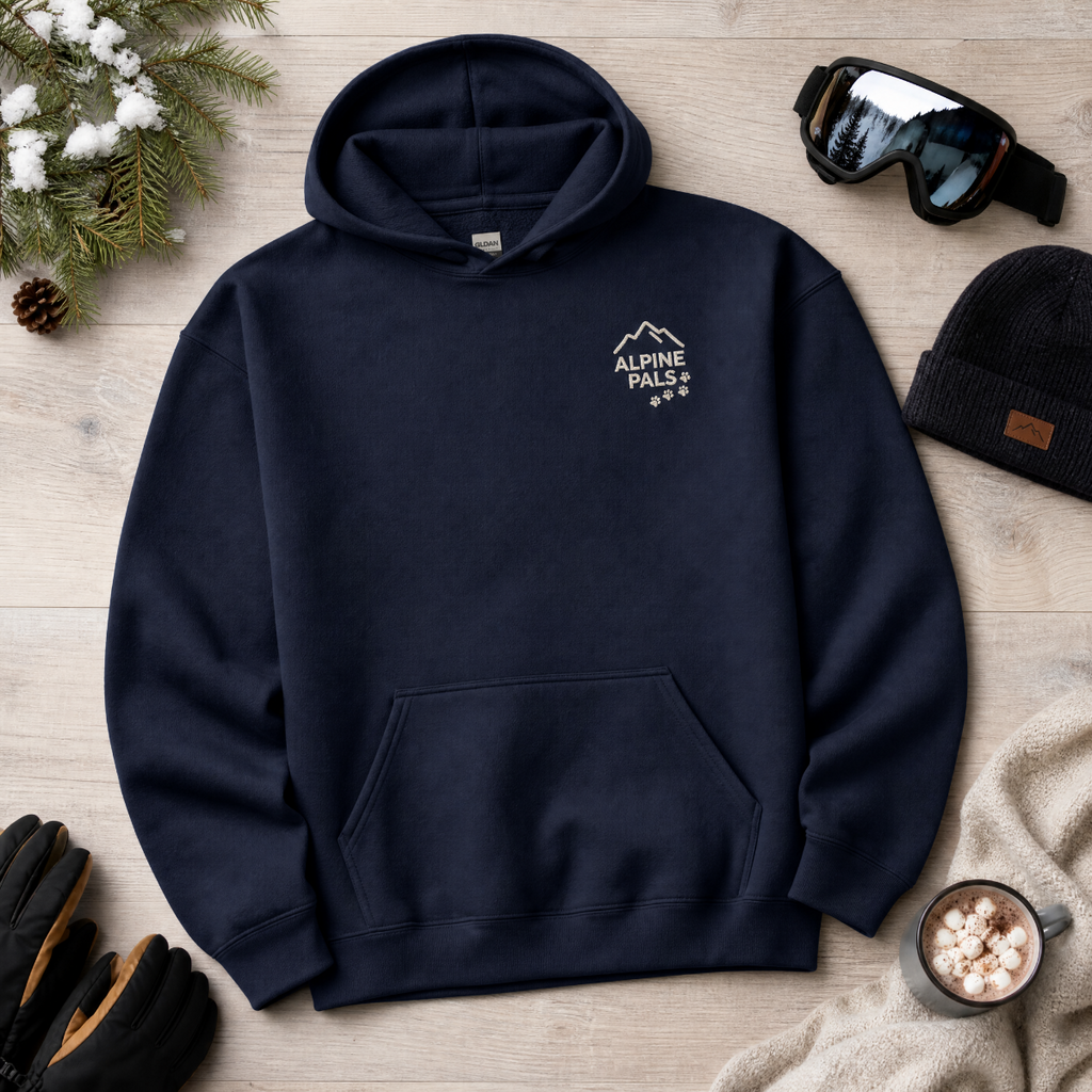 Navy blue hoodie with 'Alpine Pals' logo on a wooden surface with winter accessories.