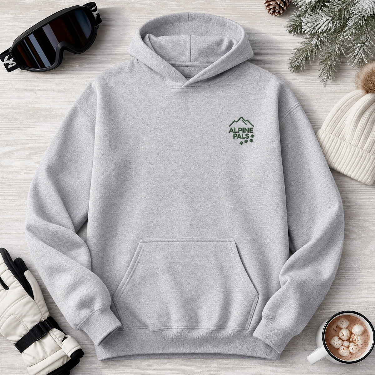 Sport grey hoodie with 'Alpine Pals' logo on a wooden surface with winter accessories.