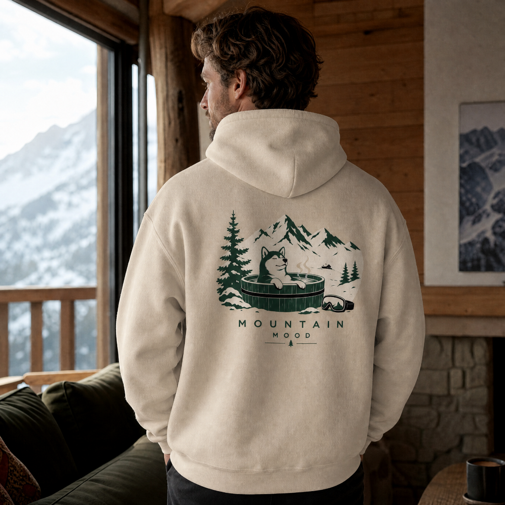 Person wearing a hoodie with a mountain-themed design in a cabin setting