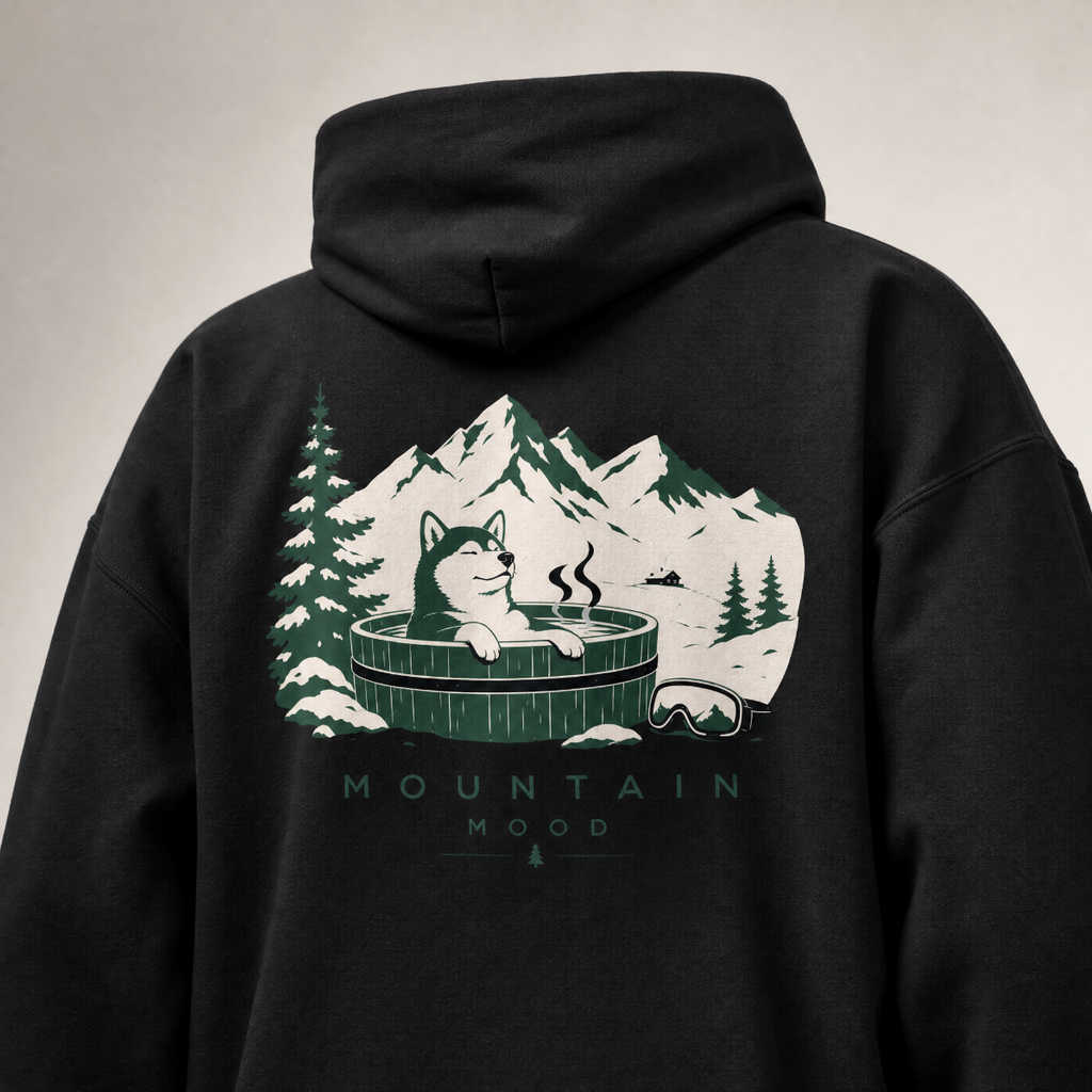 Black hoodie with a graphic of a cat in a hot tub surrounded by mountains and trees on the back.