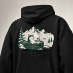 Black hoodie with a graphic of a cat in a hot tub surrounded by mountains and trees on the back.