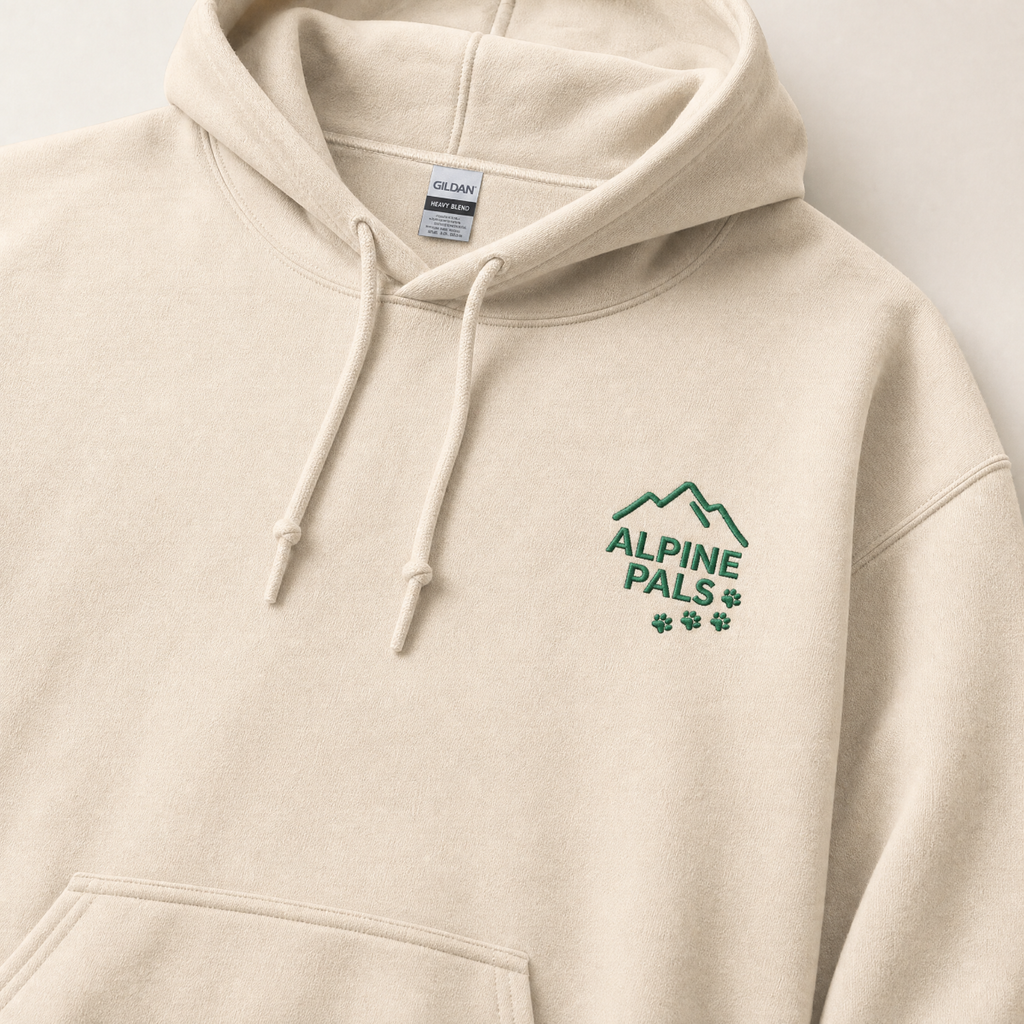 Sand colored hoodie with 'Alpine Pals' logo on a light gray background