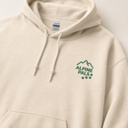 Sand colored hoodie with 'Alpine Pals' logo on a light gray background