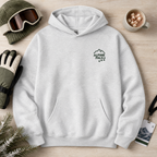 Ash gray hoodie with 'Alpine Pals' logo on a wooden surface with winter accessories.
