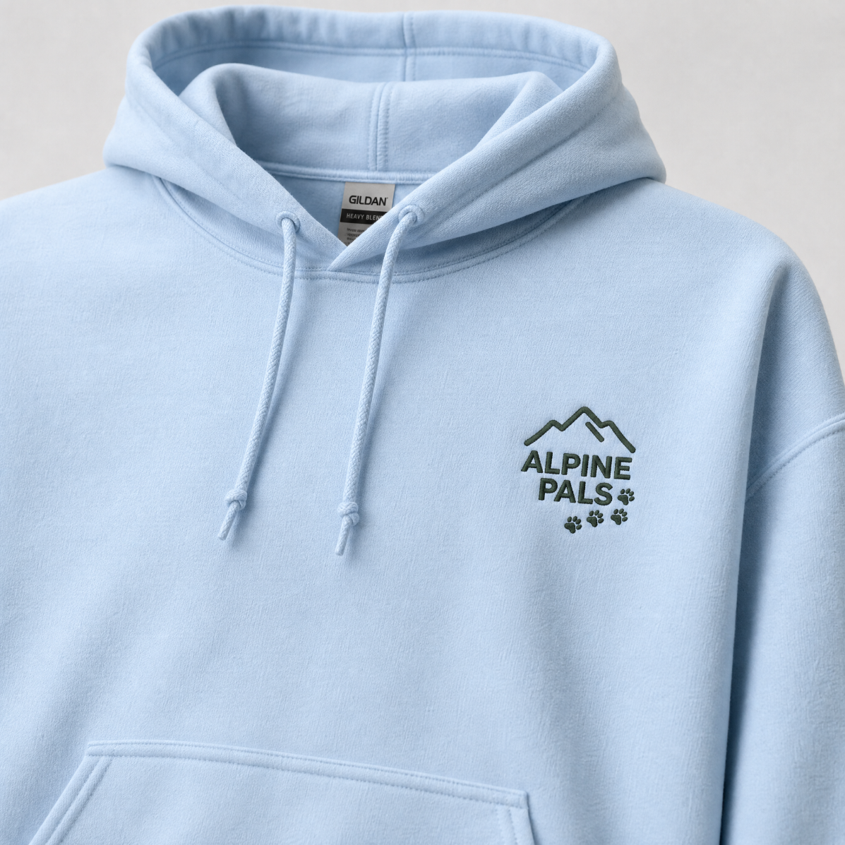 Light blue hoodie with 'Alpine Pals' logo on a neutral background