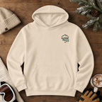 Sand colored hoodie with 'Alpine Pals' logo in front of a wooden background.