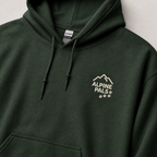 Forest green hoodie with 'Alpine Pals' logo on a light gray background