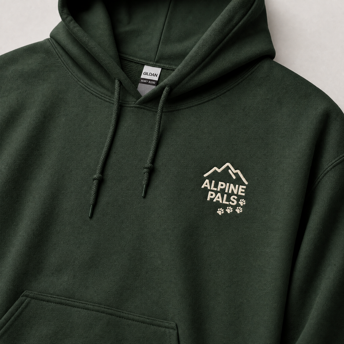 Forest green hoodie with 'Alpine Pals' logo on a light gray background
