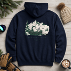 Navy blue hoodie with mountain graphic on a wooden surface with winter accessories.