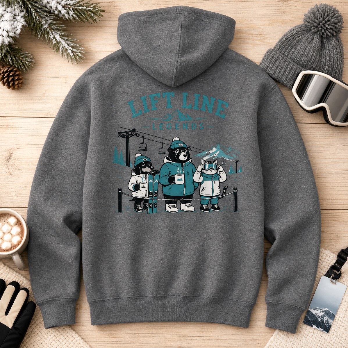 Graphite gray hoodie with bear graphic and 'Lift Line' text on a wooden surface with winter accessories.
