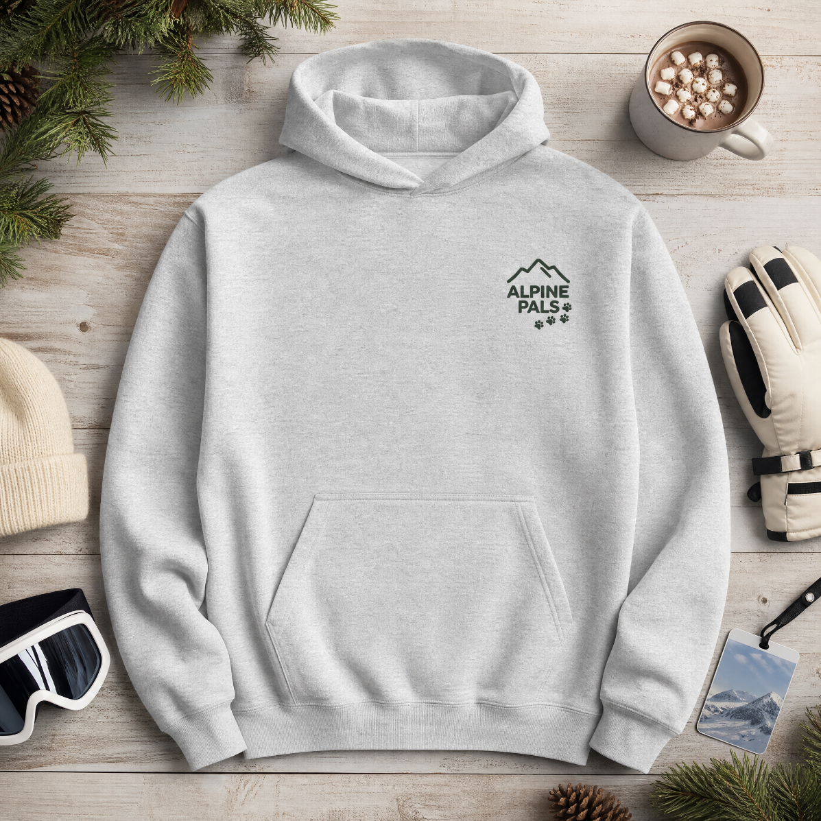 Sport grey hoodie with 'Alpine Pals' logo on a wooden surface with winter accessories.