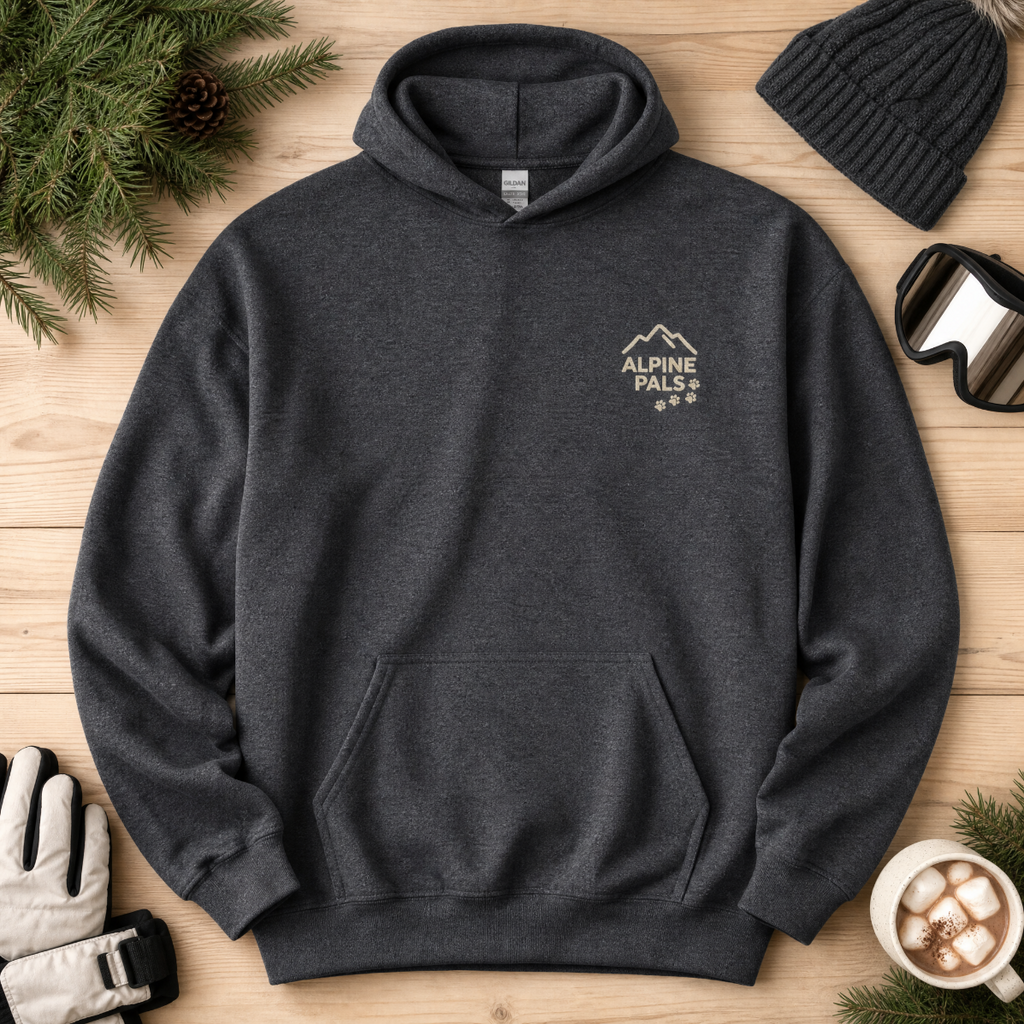 Dark heather gray hoodie with 'Alpine Pals' logo on a wooden surface with winter accessories.