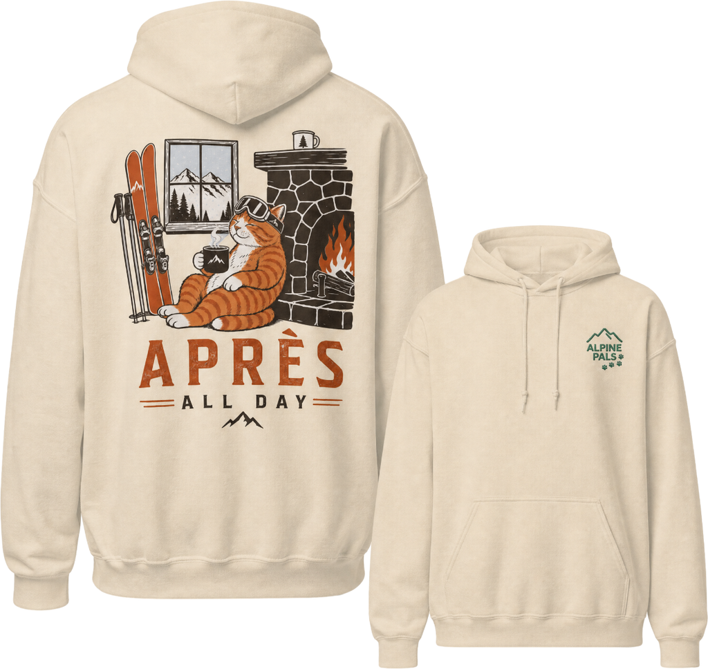 Sand colored hoodie with a graphic of a cat by a fireplace and skis, with 'Apres All Day' text on the front, and a logo on the sleeve.
