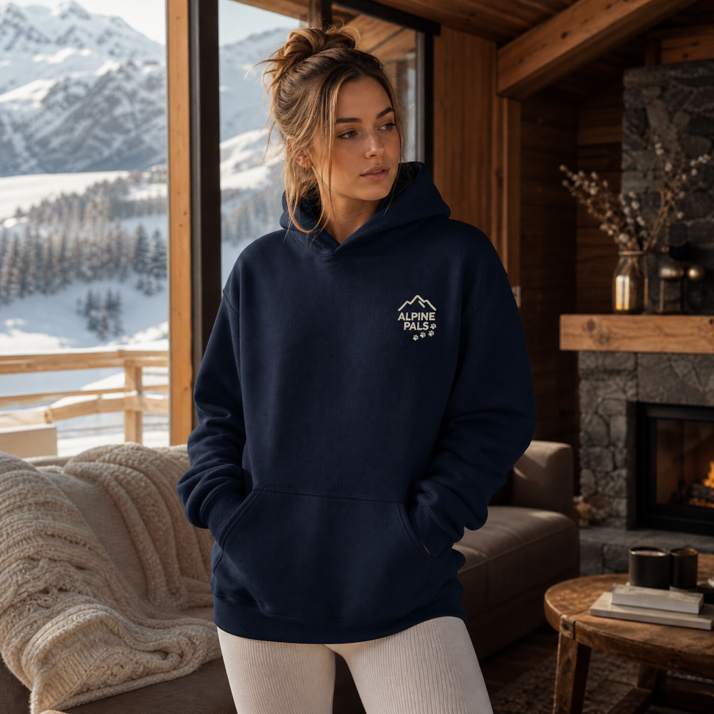 Woman wearing a navy hoodie with a logo in a cozy living room with a mountain view.