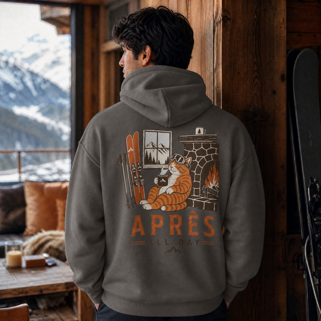 Person wearing a hoodie with a 'Apres Ski All Day' design in a mountain lodge setting