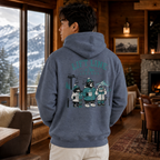 Person wearing a heather sport dark navy hoodie with a mountain-themed design, standing in a cozy room with a fireplace and mountain view.