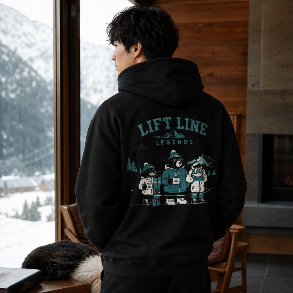 Person wearing a black hoodie with 'Lift Line Legends' design, looking out a window with snowy mountains.