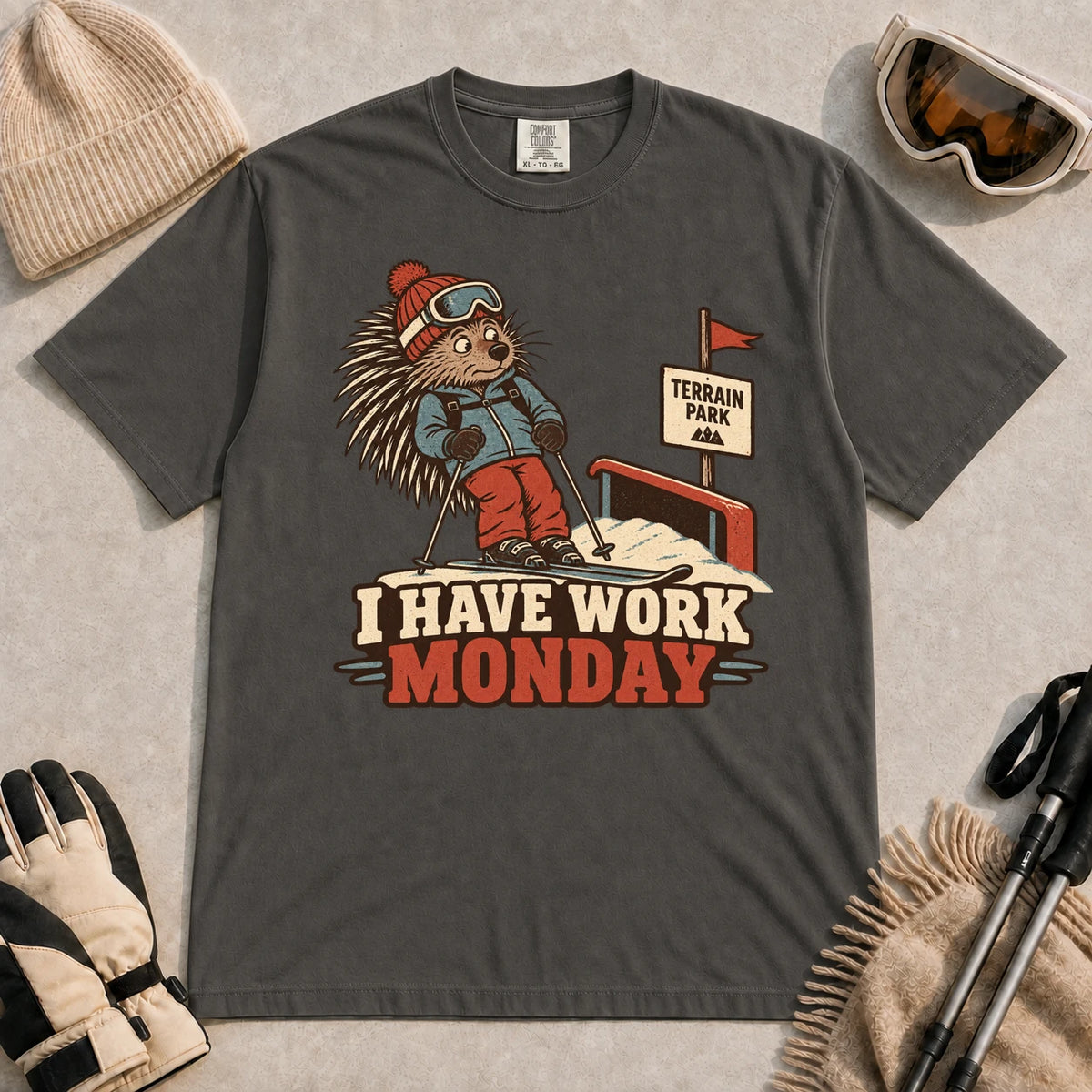 Pepper tee featuring a cautious porcupine skier beside a terrain park rail and sign above the phrase “I Have Work Monday.”
