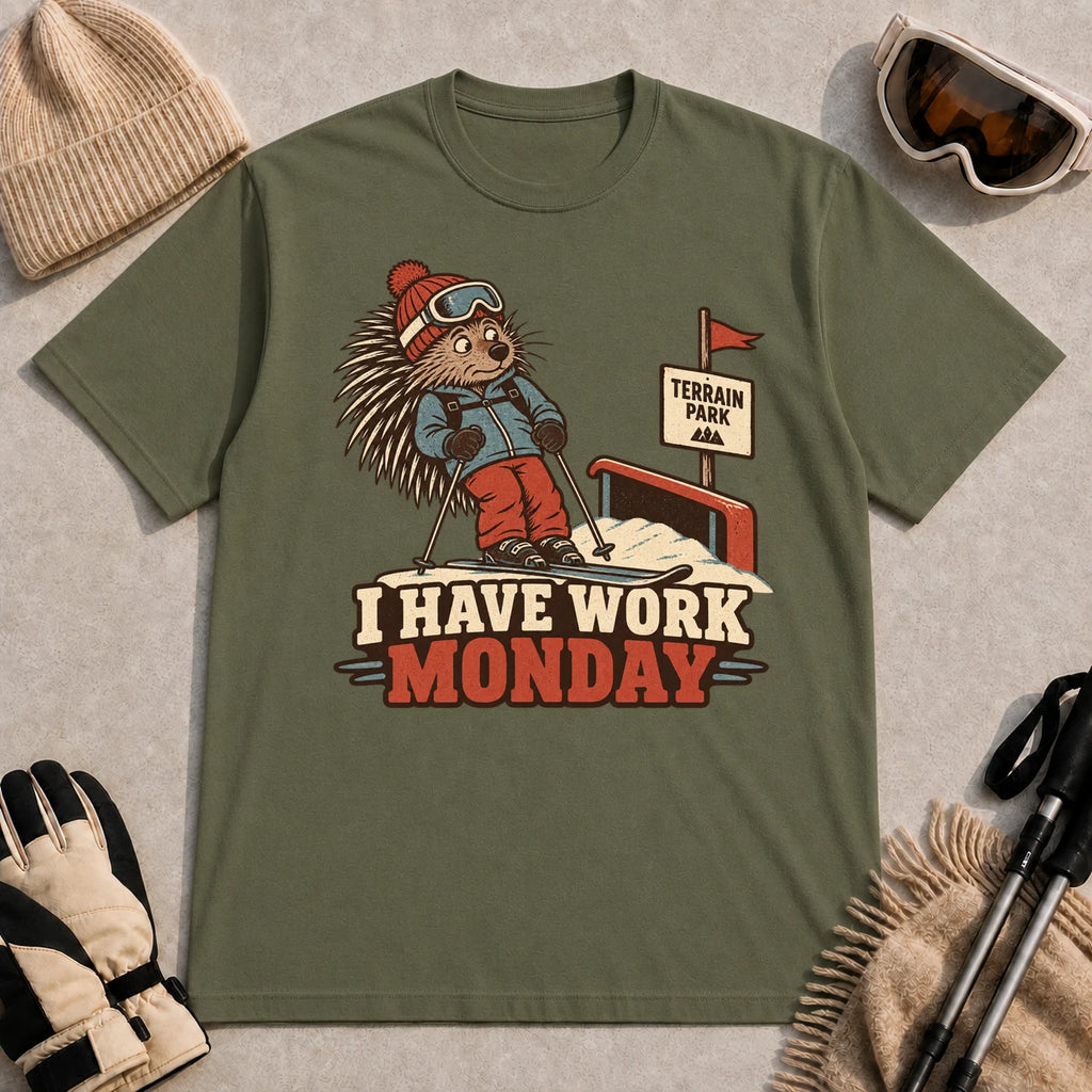 Military Green tee featuring a cautious porcupine skier beside a terrain park rail and sign above the phrase “I Have Work Monday.”