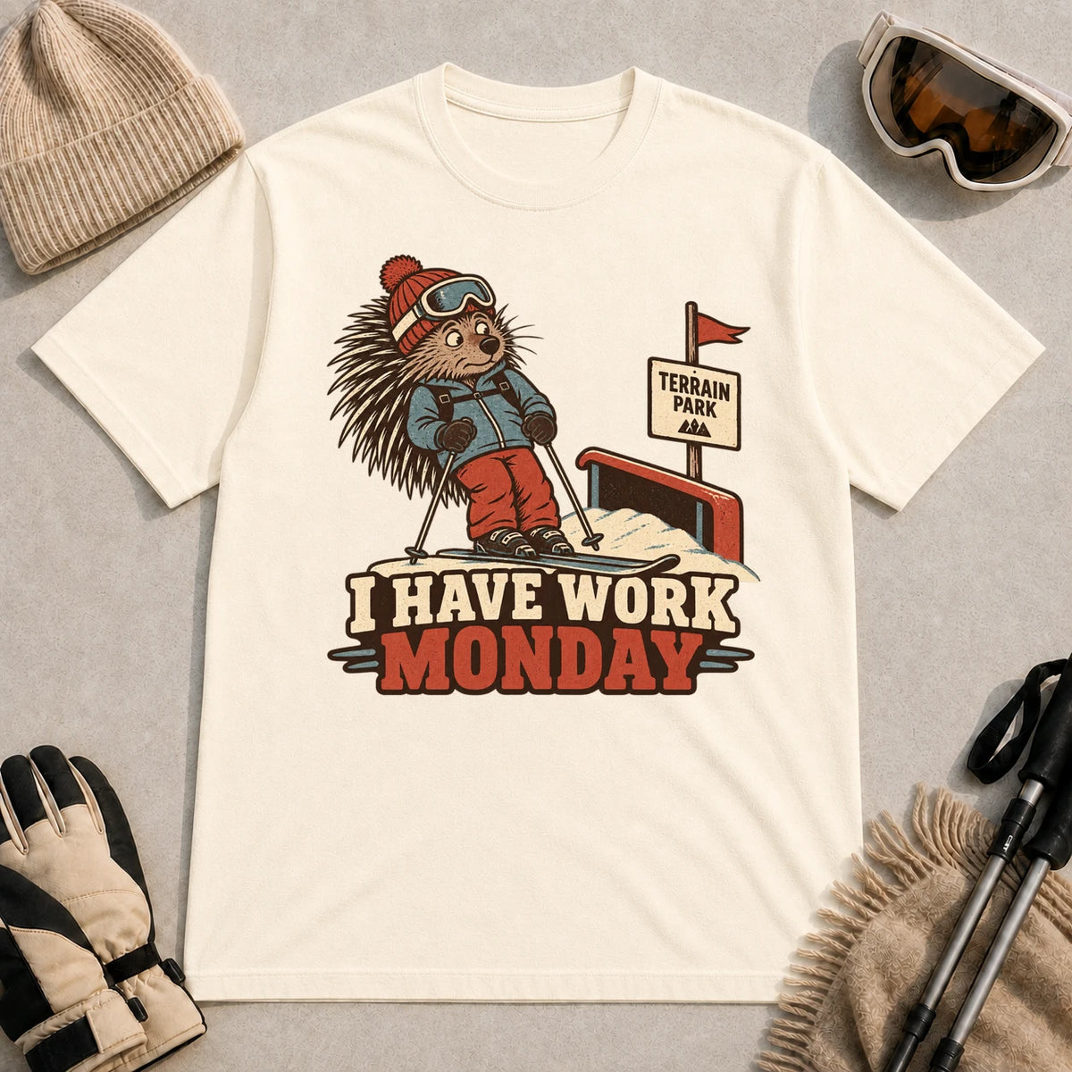 Natural tee featuring a cautious porcupine skier beside a terrain park rail and sign above the phrase “I Have Work Monday.”