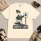 Ivory tee featuring a cool duck skier pointing to a blue-square trail sign above the phrase “I Know My Limits.”