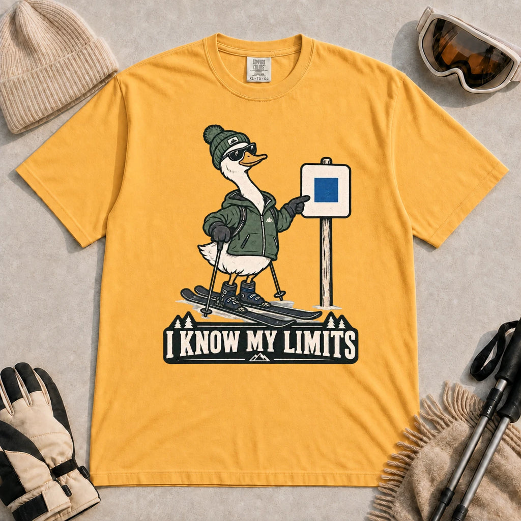 Mustard tee featuring a cool duck skier pointing to a blue-square trail sign above the phrase “I Know My Limits.”