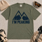 Moss tee featuring a distressed navy double-mountain graphic above the phrase “I’m Peaking.”