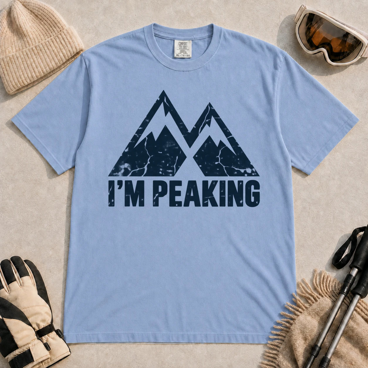 Washed Denim tee featuring a distressed navy double-mountain graphic above the phrase “I’m Peaking.”