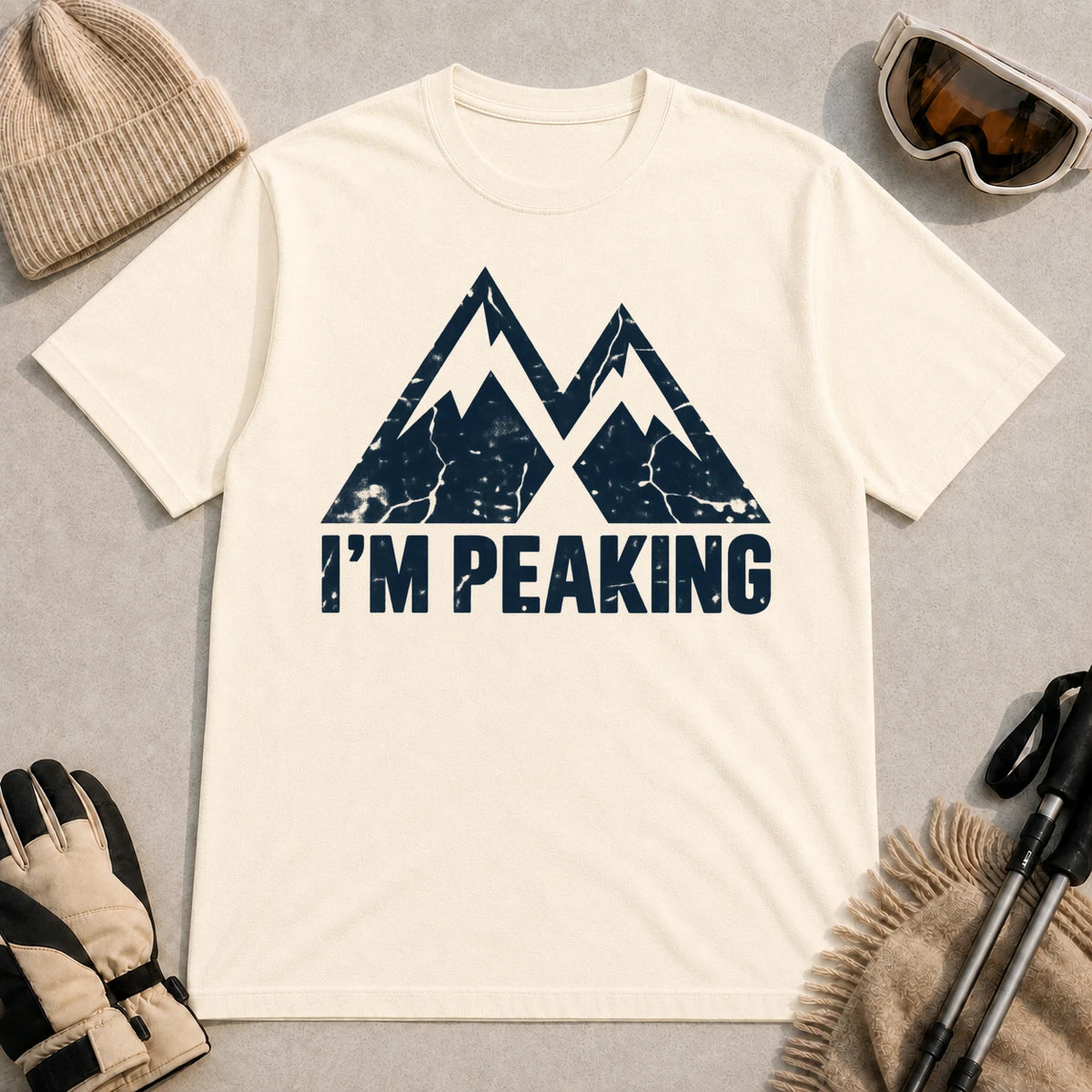 Natural tee featuring a distressed navy double-mountain graphic above the phrase “I’m Peaking.”