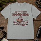 Granite tee featuring a fox mountain biking through a minimalist trail scene with the phrases “Just Start Mountain Biking,” “No Perfect Time,” and “Just Pedal and Go.”