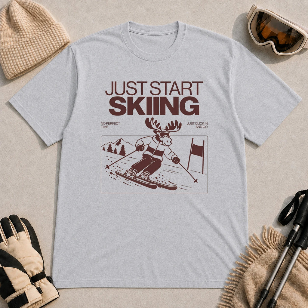 Sport Grey tee featuring a moose skiing through a minimalist mountain scene with the phrases “Just Start Skiing,” “No Perfect Time,” and “Just Click In and Go.”