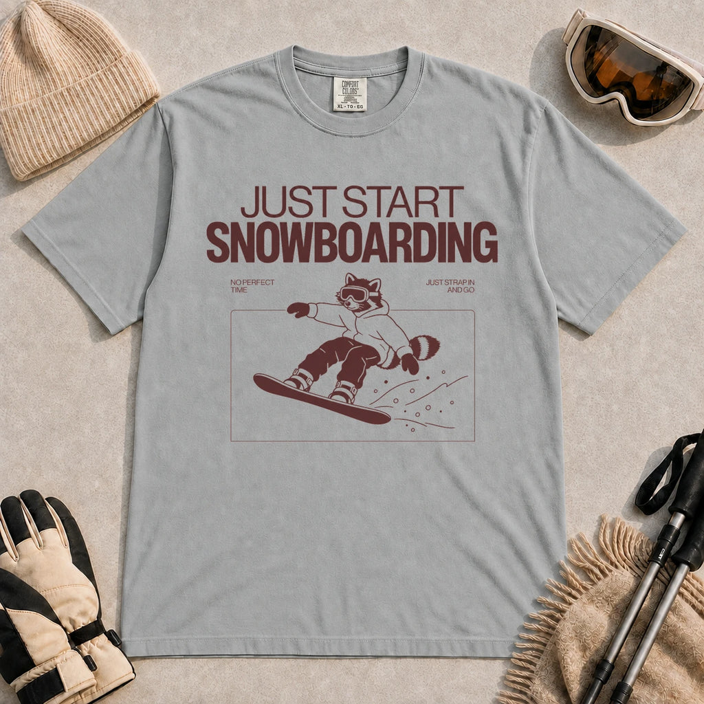 Granite tee featuring a raccoon snowboarding through a minimalist slope scene with the phrases “Just Start Snowboarding,” “No Perfect Time,” and “Just Strap In and Go.”