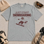 Granite tee featuring a raccoon snowboarding through a minimalist slope scene with the phrases “Just Start Snowboarding,” “No Perfect Time,” and “Just Strap In and Go.”