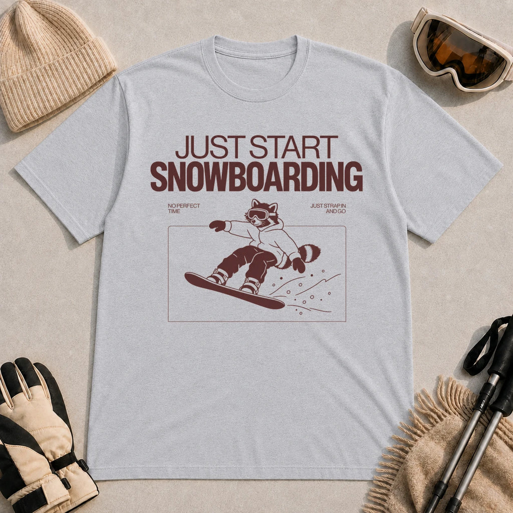 Sport Grey tee featuring a raccoon snowboarding through a minimalist slope scene with the phrases “Just Start Snowboarding,” “No Perfect Time,” and “Just Strap In and Go.”