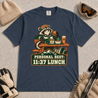 Midnight tee featuring a relaxed raccoon enjoying a burger and fries at a mountain lodge table above the phrase “Personal Best: 11:37 Lunch.”