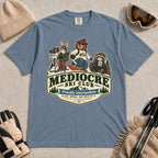 Blue Jean tee featuring a bear, bunny, and raccoon in ski gear above a retro “Mediocre Ski Club” badge with the phrases “Proudly Intermediate” and “Blues, Brews, and Back by 4.”