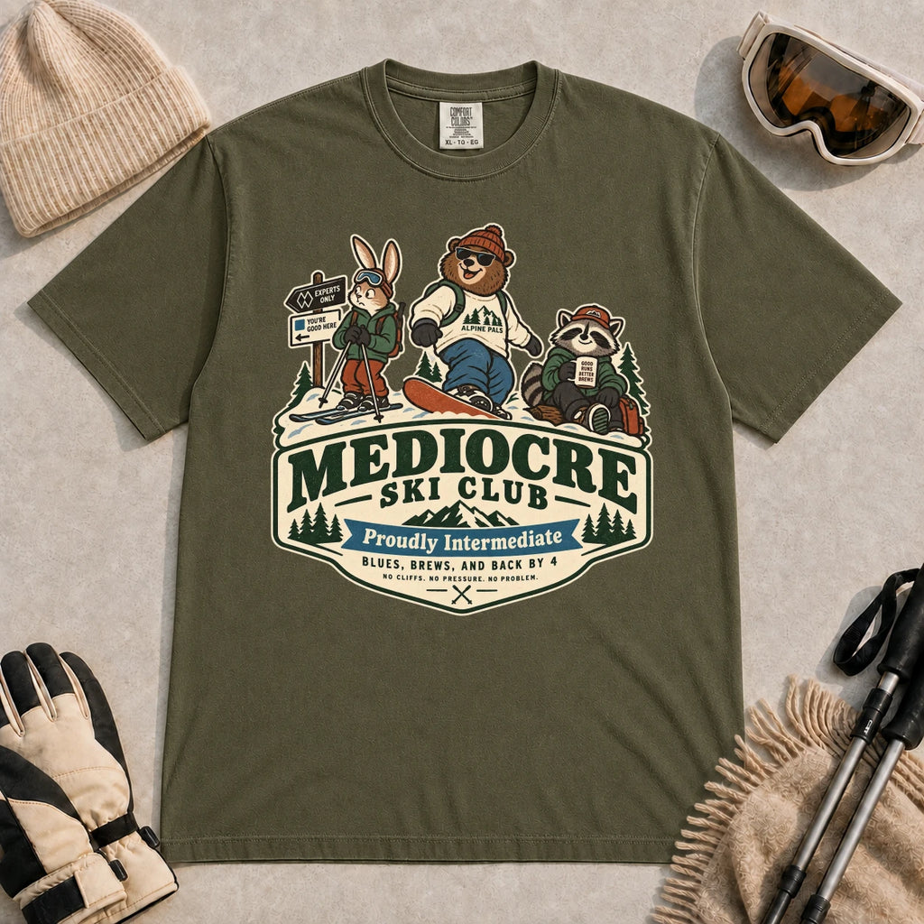 Hemp tee featuring a bear, bunny, and raccoon in ski gear above a retro “Mediocre Ski Club” badge with the phrases “Proudly Intermediate” and “Blues, Brews, and Back by 4.”