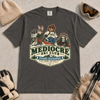 Pepper tee featuring a bear, bunny, and raccoon in ski gear above a retro “Mediocre Ski Club” badge with the phrases “Proudly Intermediate” and “Blues, Brews, and Back by 4.”