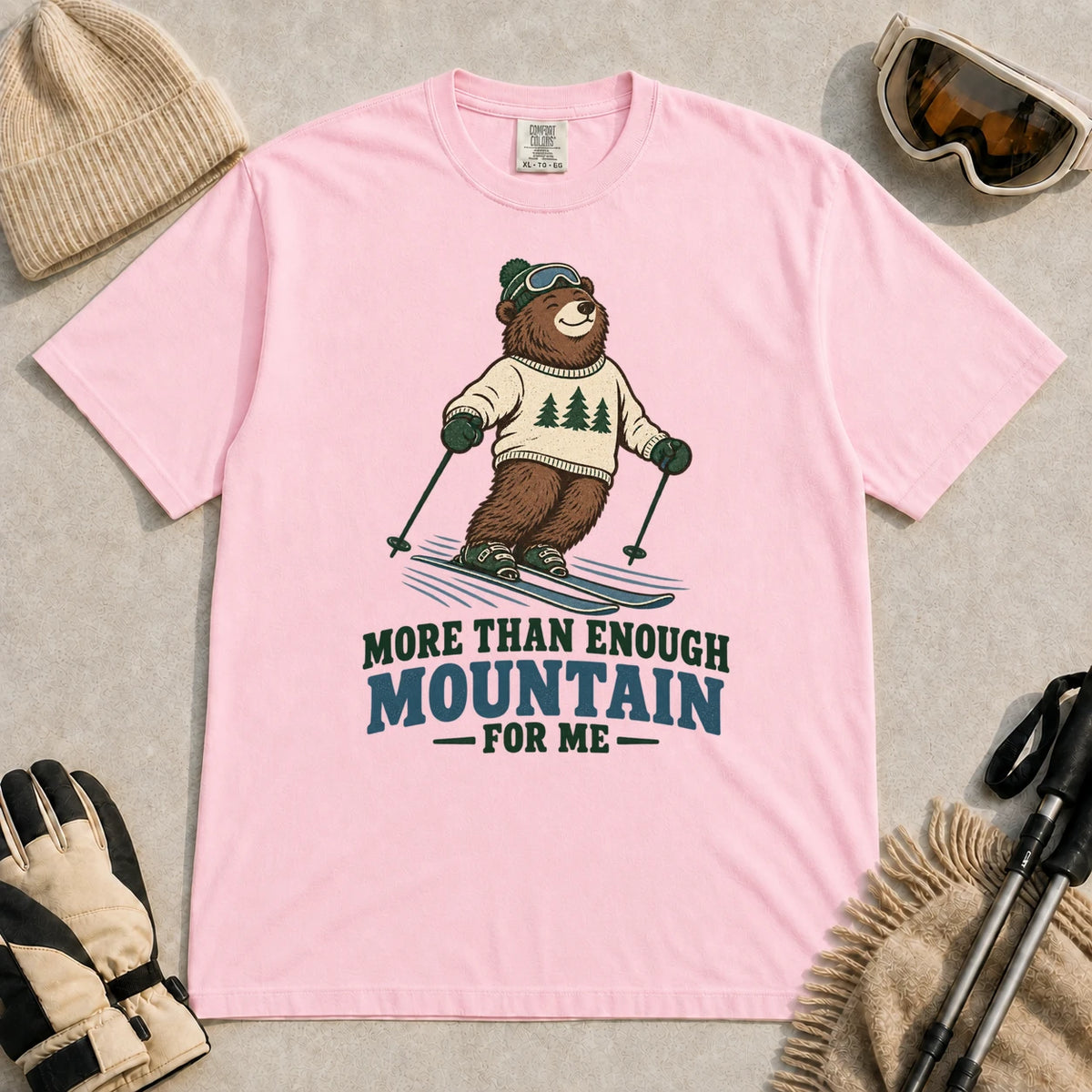 Blossom tee featuring a smiling bear skiing in retro mountain gear above the phrase “More Than Enough Mountain for Me.”