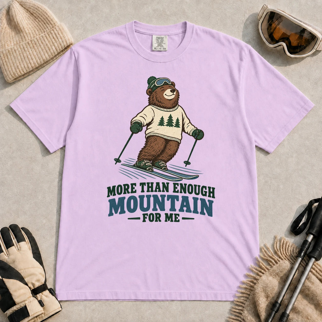 Orchid tee featuring a smiling bear skiing in retro mountain gear above the phrase “More Than Enough Mountain for Me.”