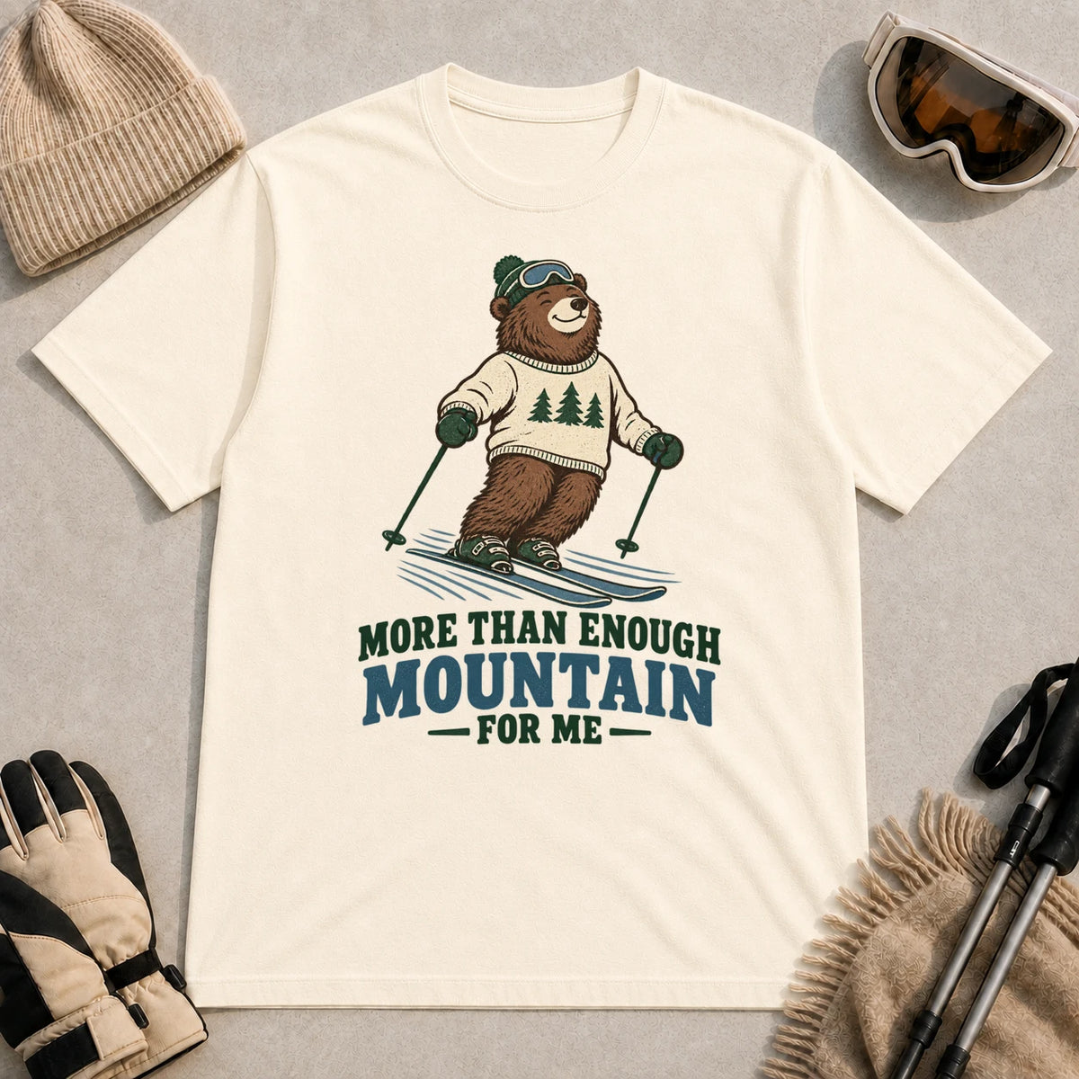 Natural tee featuring a smiling bear skiing in retro mountain gear above the phrase “More Than Enough Mountain for Me.”