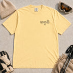 Butter tee featuring minimalist black line art of a bear, raccoon, and bunny wearing ski goggles above a small pair of crossed skis.