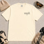Ivory tee featuring minimalist black line art of a bear, raccoon, and bunny wearing ski goggles above a small pair of crossed skis.