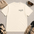 Natural tee featuring minimalist black line art of a bear, raccoon, and bunny wearing ski goggles above a small pair of crossed skis.