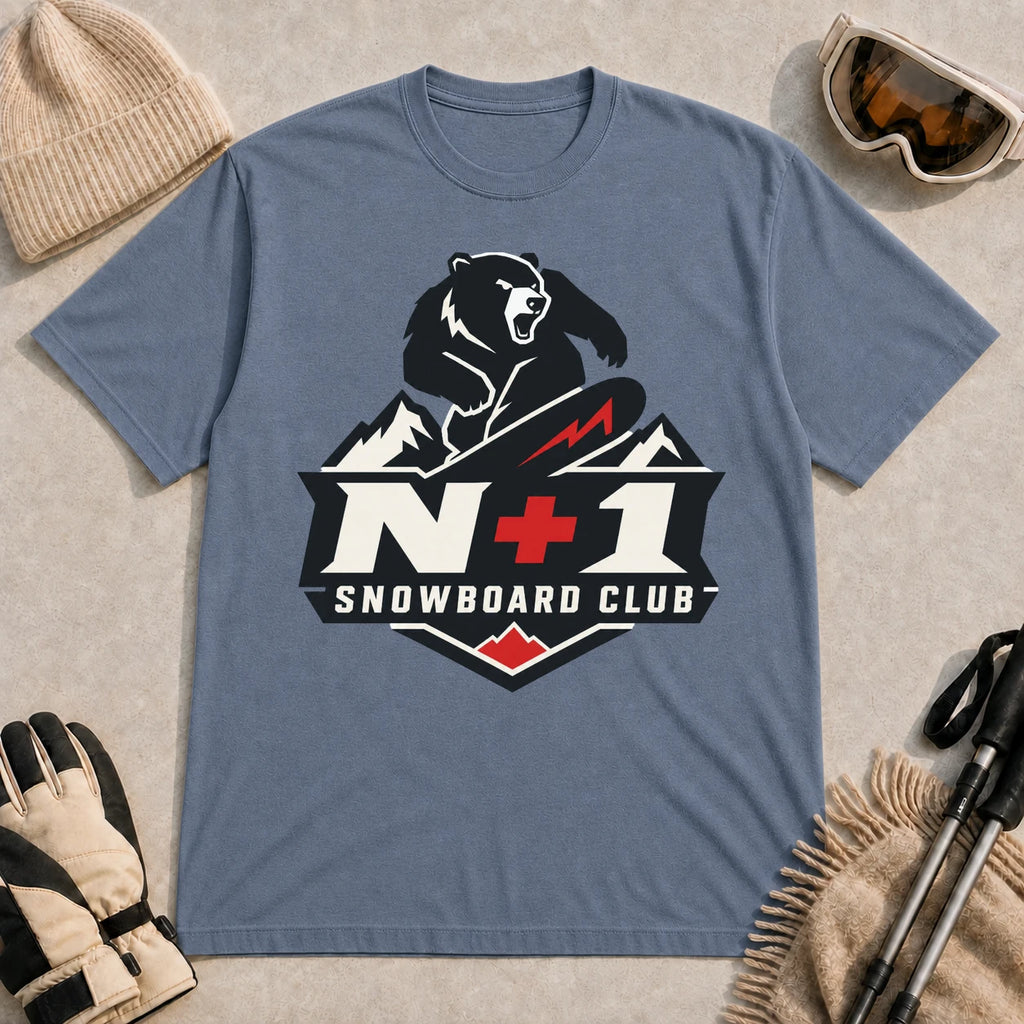Heather Indigo tee featuring a bear snowboarding above a bold mountain badge with the phrase “N+1 Snowboard Club.”