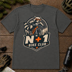 Dark Heather Gray tee featuring a sunglasses-wearing raccoon mountain biking above a bold badge with the phrase “N+1 Bike Club.”