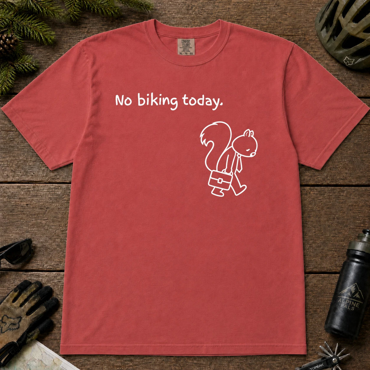 Crimson tee featuring a sad squirrel dressed for work and carrying a briefcase beneath the phrase “No biking today.”