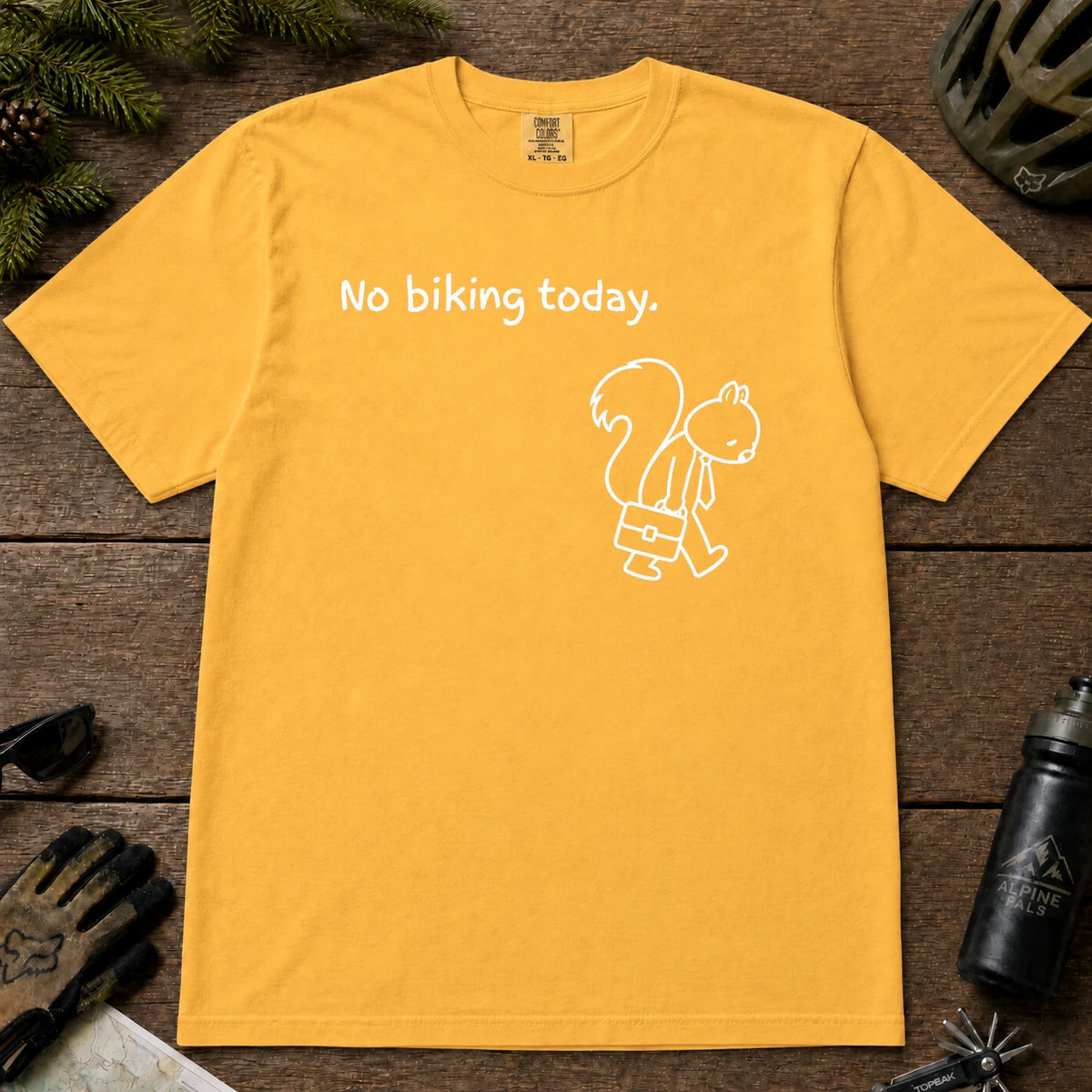 Mustard tee featuring a sad squirrel dressed for work and carrying a briefcase beneath the phrase “No biking today.”